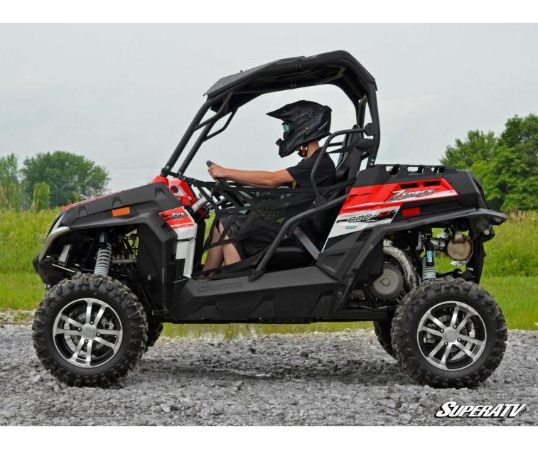 Side view of the red CFMoto ZForce 800EX with a rider showing the stance from the SuperATV 2-inch lift kit