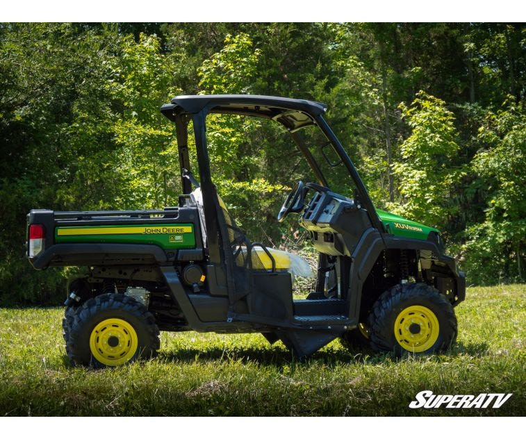 Side profile of a lifted John Deere Gator XUV 835 with the SuperATV 2 inch lift kit on a grass field
