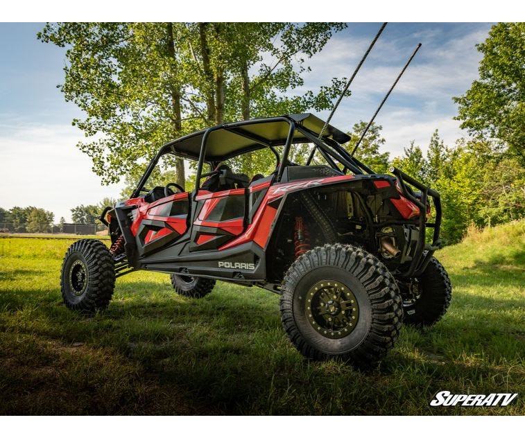 Red four-seat Polaris RZR XP Turbo S with the SuperATV 3-inch lift kit installed, low rear three-quarter view in grass