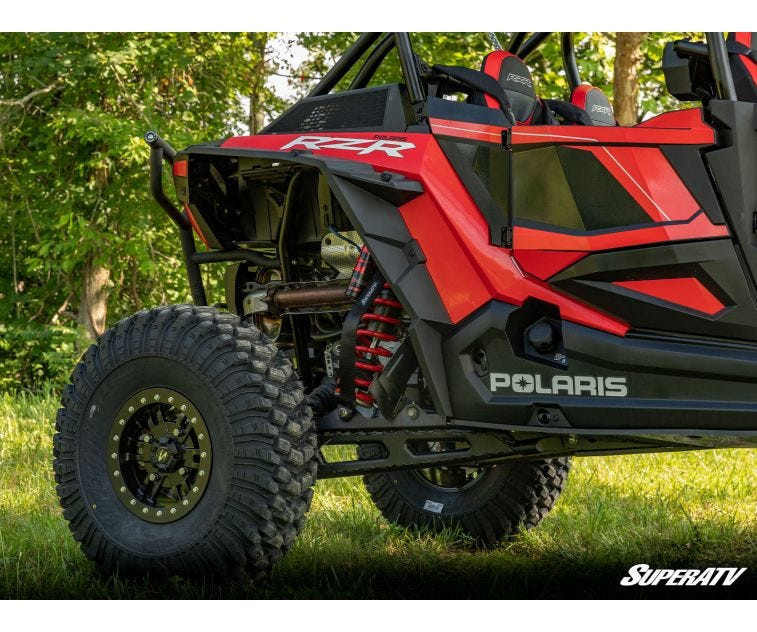 Rear wheel and fender of a red Polaris RZR XP Turbo S showing added ride height from the SuperATV 3-inch lift kit