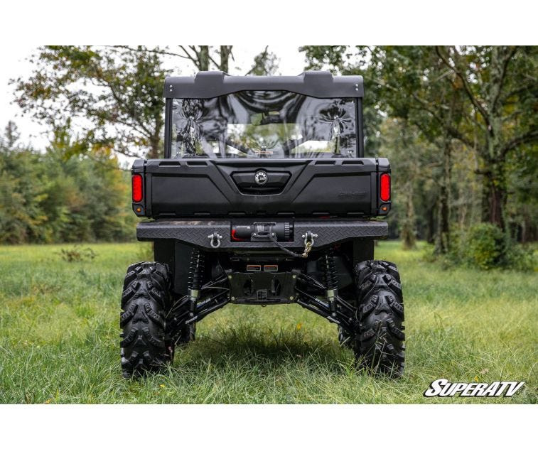 Rear view of the yellow and black Can-Am Defender showing the ground clearance from the SuperATV 6-inch lift