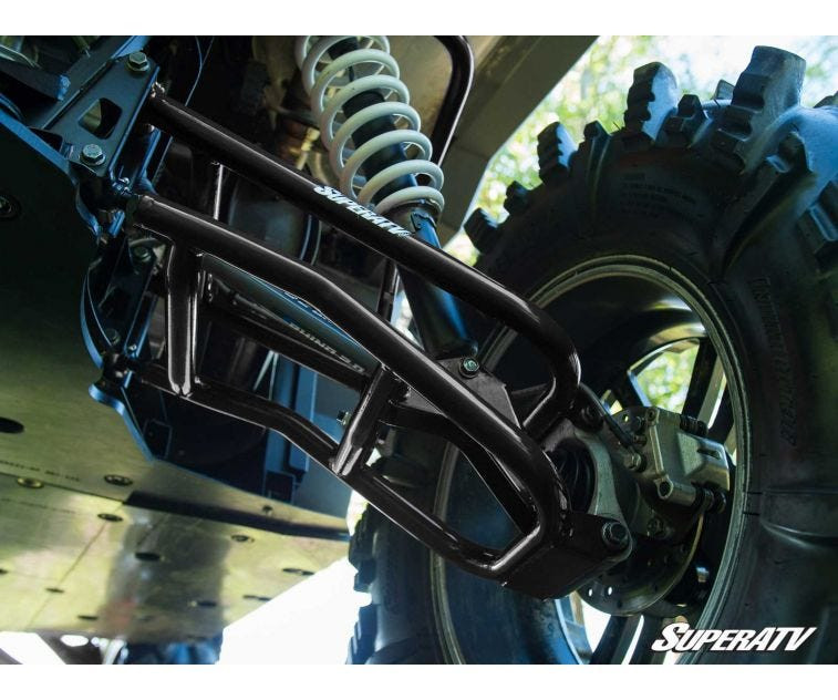 Close-up of a black SuperATV rear control arm at the Ranger XP 1000 wheel hub with mud tire tread behind it