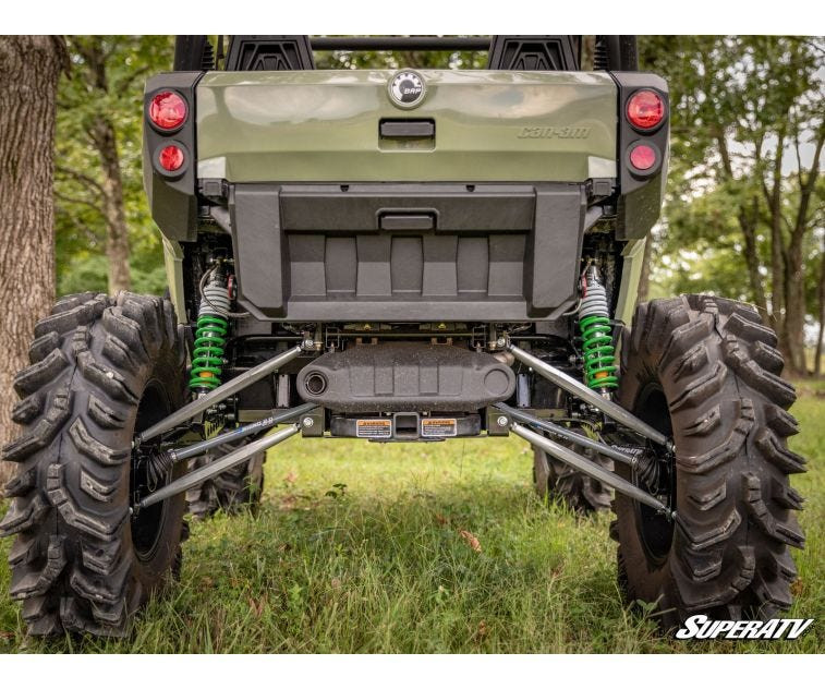 Rear view of a green Can-Am Commander lifted 6 inches with the SuperATV kit, green shocks and mud tires in a field