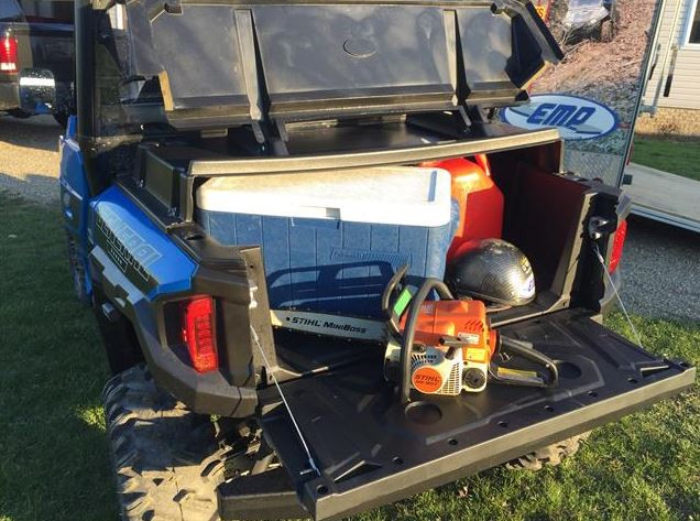 Rear view of the open Extreme Metal Products bed cover on a Polaris General XP 1000 with a cooler and gear inside