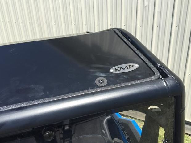Top surface of the Extreme Metal Products aluminum roof with the EMP badge, viewed from above the Polaris General 1000 cage