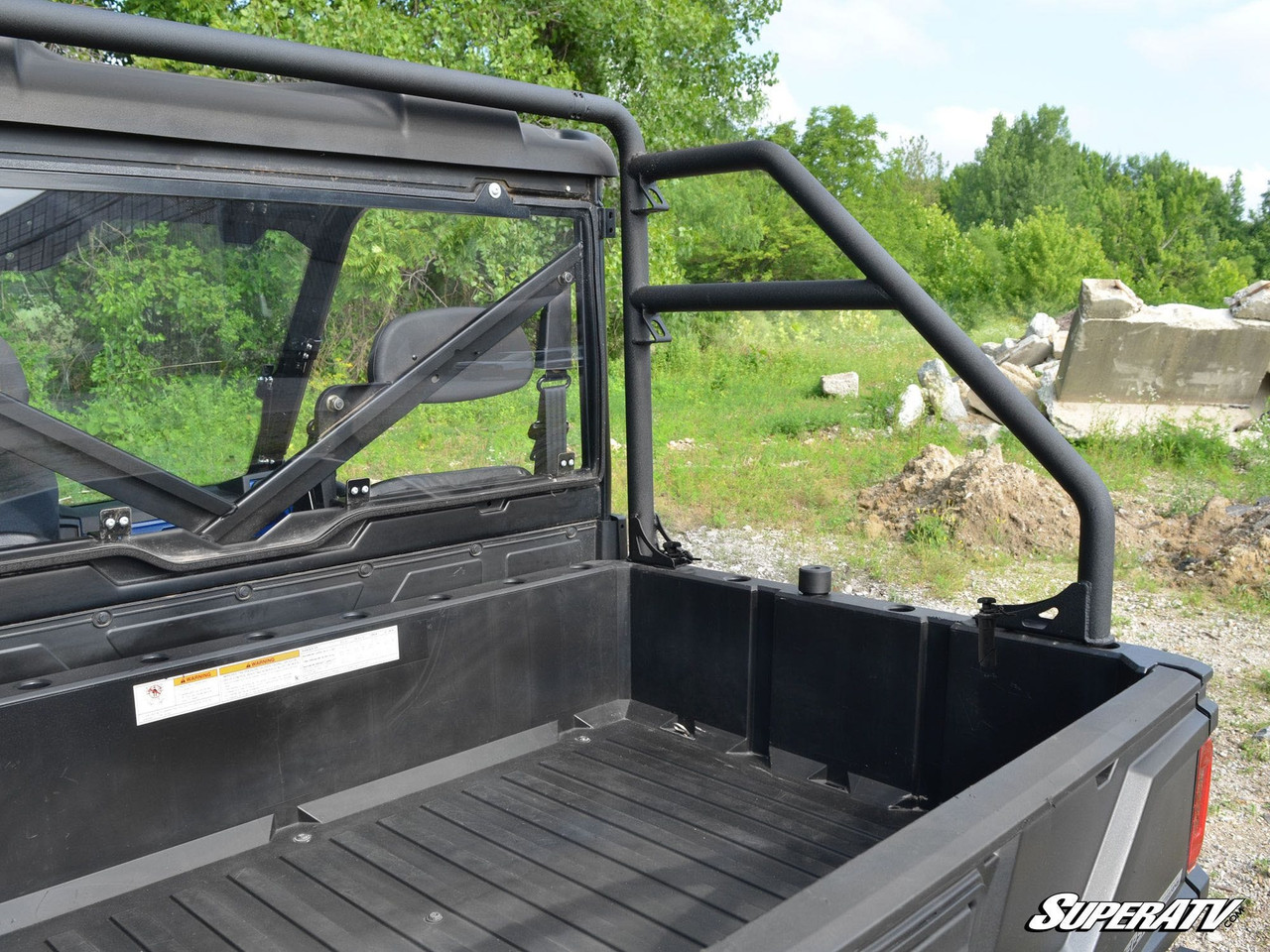 Rear cargo bed view of the Polaris Ranger showing the SuperATV rear roll cage support bars behind the rear window