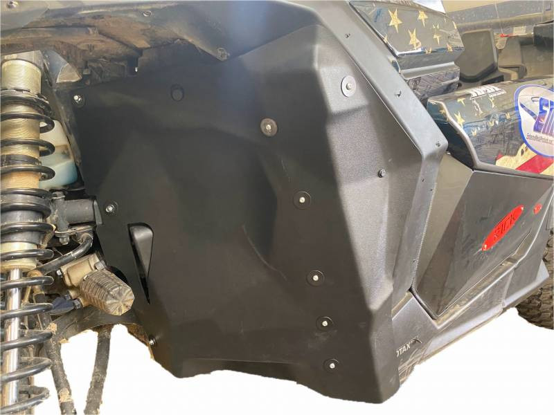 Extreme Metal Products firewall liner installed behind the front wheel of a Can-Am Maverick X3 in a garage