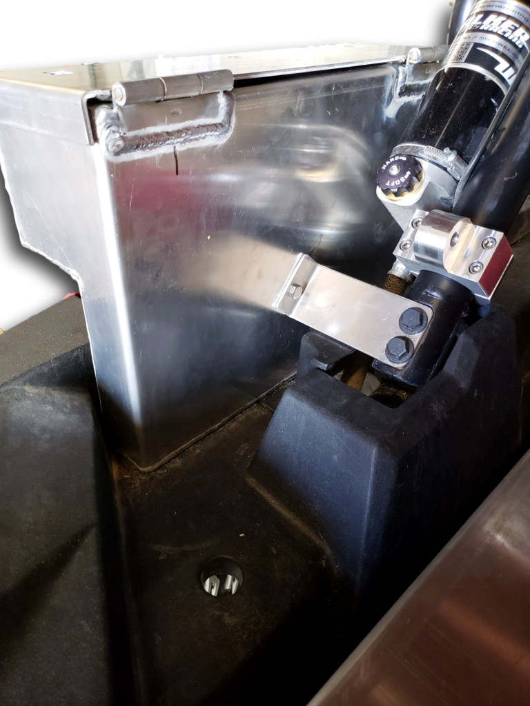 Close-up of a raw aluminum Hi-Standard cargo box with its bracket bolted beside the RZR 1000 shock