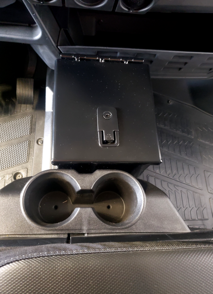 Top-down view of the closed Hi-Standard center console box and lock in a Polaris Ranger with cup holders in front