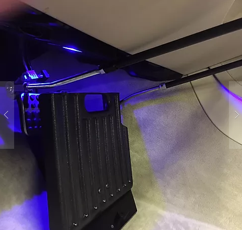 Sure Grip gas and brake guard installed in a vehicle footwell under blue interior lighting, angled view