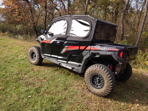 Rear three-quarter view of the Polaris General 4 with the Side X Side upper doors and rear window, in the woods