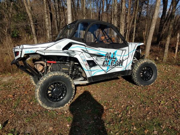 Side profile of the Arctic Cat Wildcat XX with the Side X Side upper doors kit closed, parked in the woods