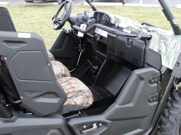 Wide view of the camo Yamaha Viking cab showing the Sure Grip hand control lever beside the steering wheel and seats