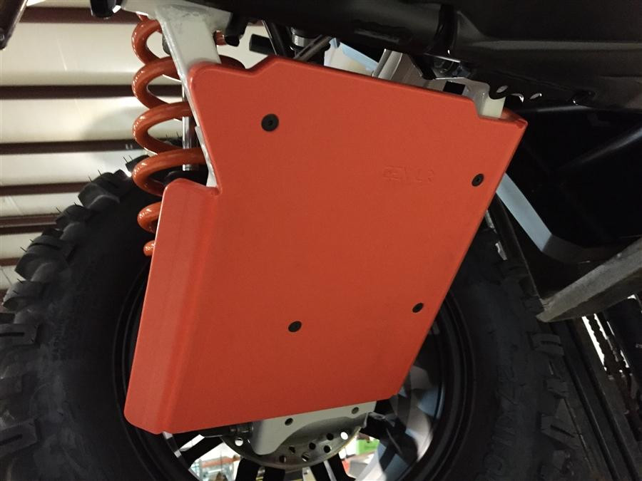 Close-up of an orange Trail Armor A-arm guard mounted under the front A-arm of a Polaris General 1000