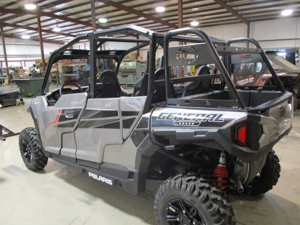 Side view of a silver Polaris General 1000 with the Trail Armor rear rack over the cargo bed, parked in a shop