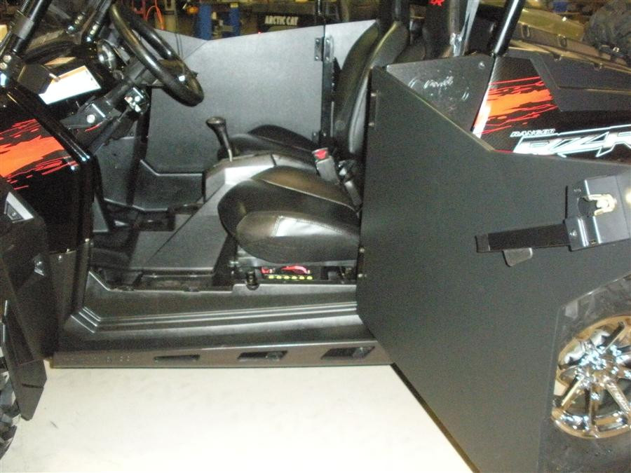 Trail Armor Slimline door debris shield swung open on the black Polaris RZR, showing the hinge and latch side