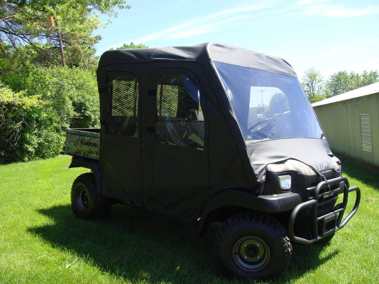 Front three-quarter view of a Kawasaki Mule 3010 Trans with the 3 Star vinyl windshield and cab enclosure