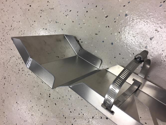 Universal Parts exhaust guard on a garage floor showing the underside and stainless band clamp