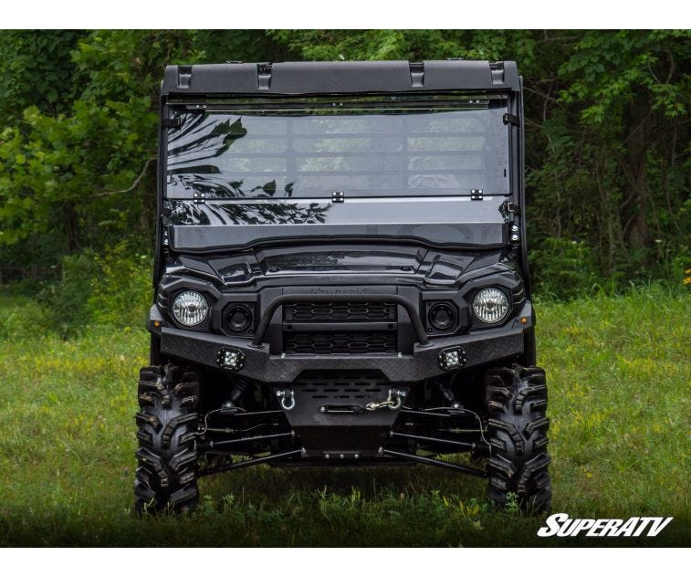 SuperATV scratch resistant flip down windshield installed on a black Kawasaki Mule Pro, front view in a field