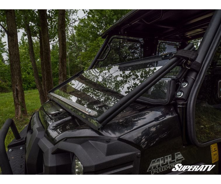 Side angle of the SuperATV flip down windshield in the lowered position on a Kawasaki Mule Pro with hood visible