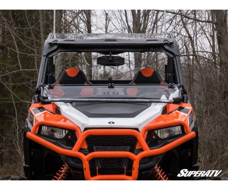SuperATV scratch-resistant flip down windshield on an orange Polaris General, front view in the woods