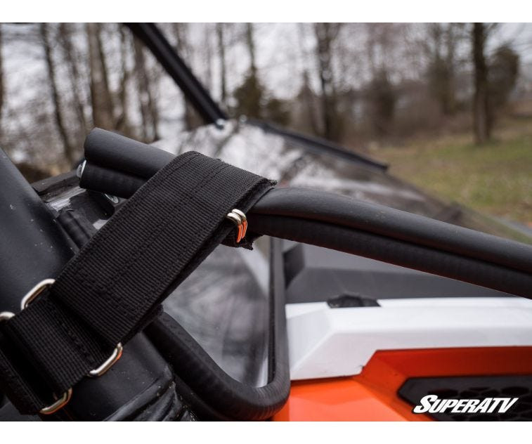 Close-up of the black strap and buckle holding the SuperATV flip down windshield to the Polaris General cage