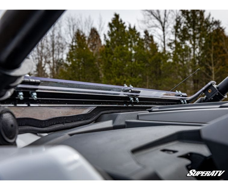Close-up of the SuperATV flip down windshield hinge and latch at the roof line of a Polaris RZR PRO XP