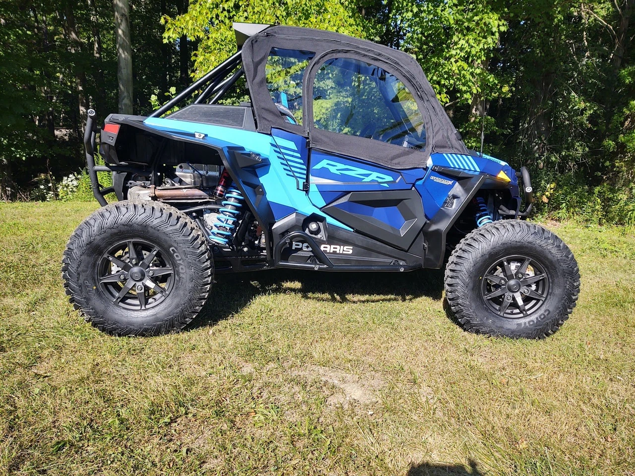 Side X Side upper doors kit with soft cab installed on a blue Polaris RZR Turbo S, side view on grass