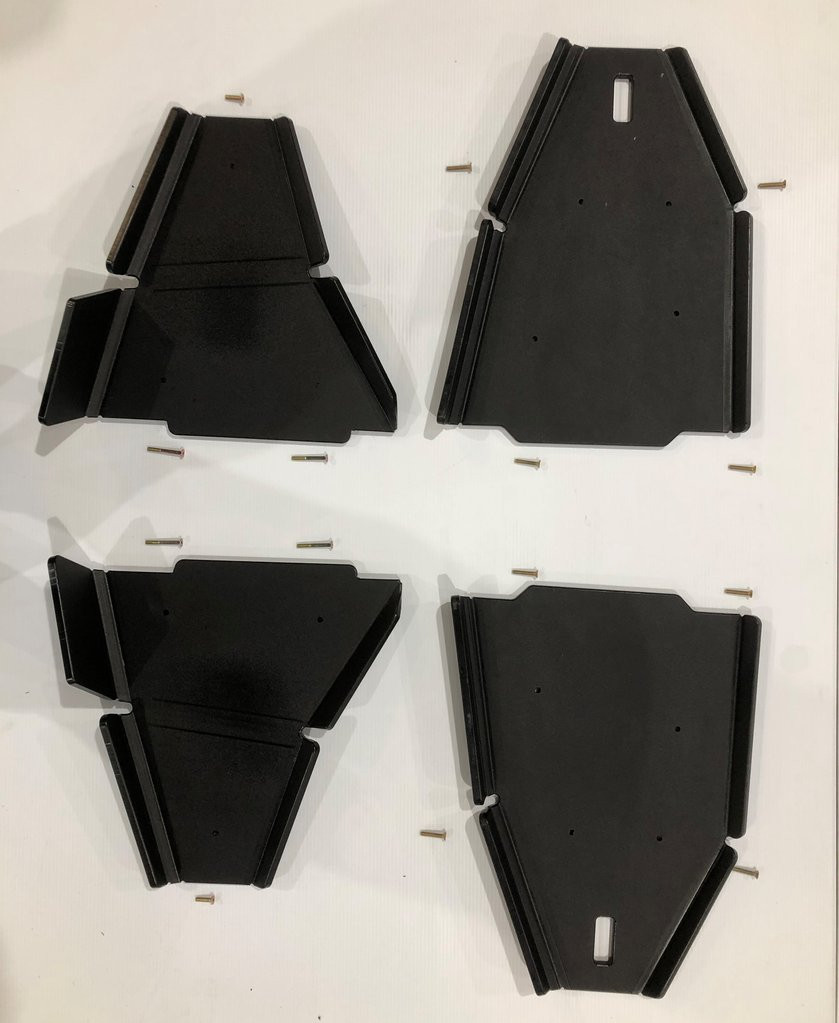 Four Trail Armor iMpact A-arm guard panels for the Wolverine RMAX2 laid out on white with mounting hardware