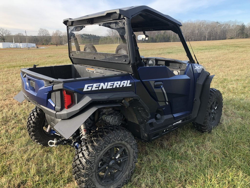 Trail Armor rear window dust shield installed on a blue Polaris General 1000, rear three-quarter view in a field