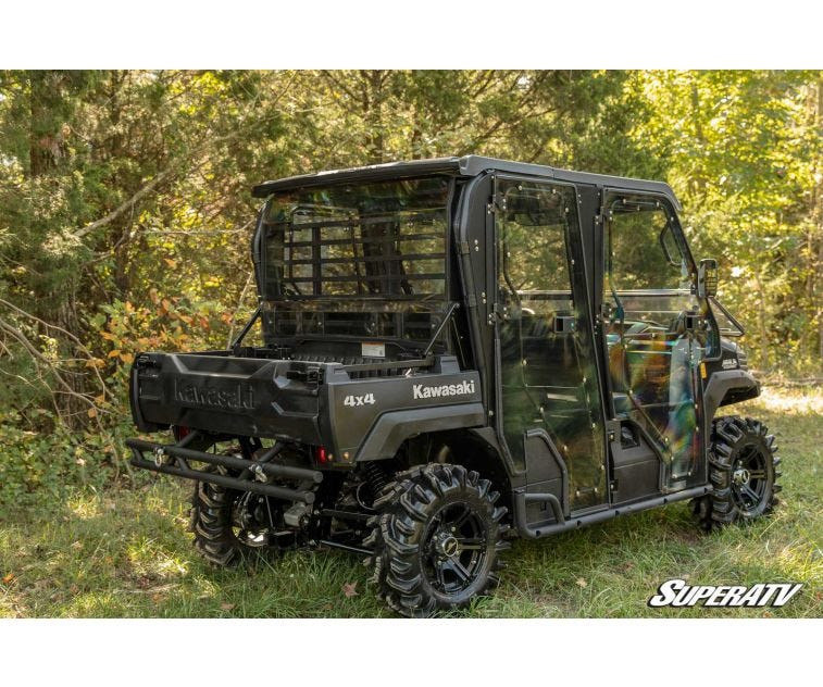 Rear three-quarter view of a camo Kawasaki Mule Pro in the woods with the SuperATV rear windshield installed