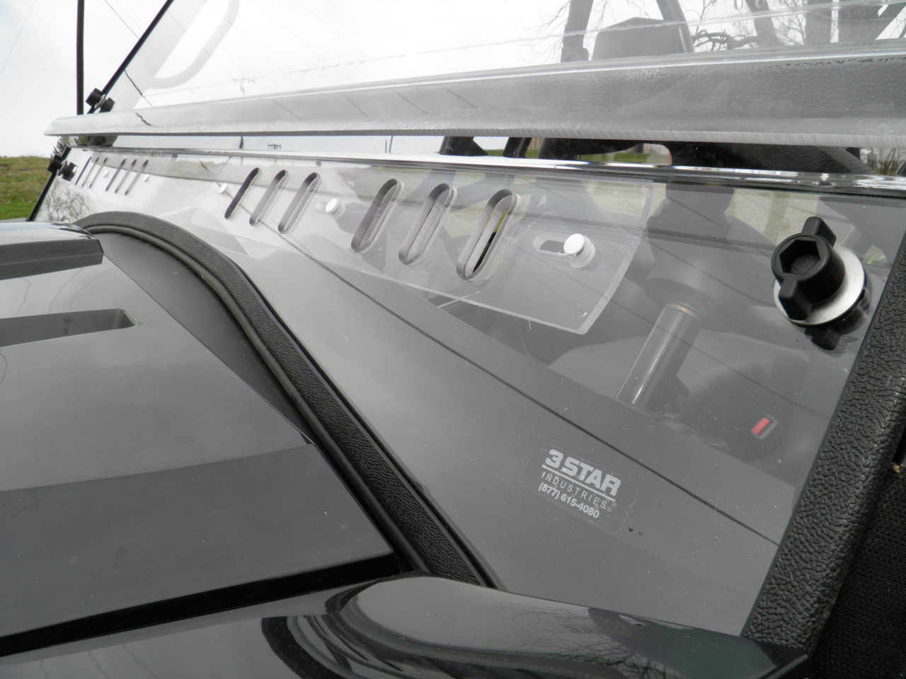 Close-up of the 3 Star two-piece windshield lower vent slots and rubber trim on the hood of an Arctic Cat Prowler 700