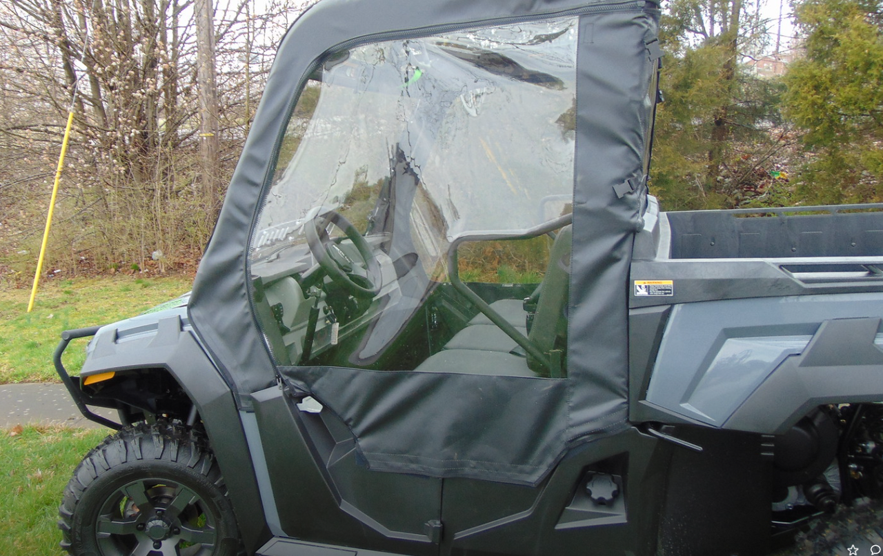 Side view of the 3 Star soft door with clear window zipped closed on a gray Arctic Cat Prowler Pro