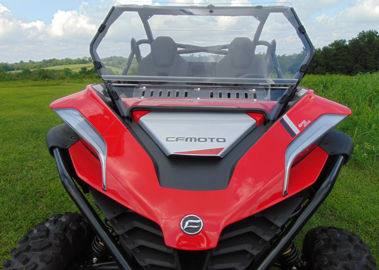 Front view of the 3 Star 2-piece windshield on a red CF Moto ZForce 950 in a grassy field with soft top