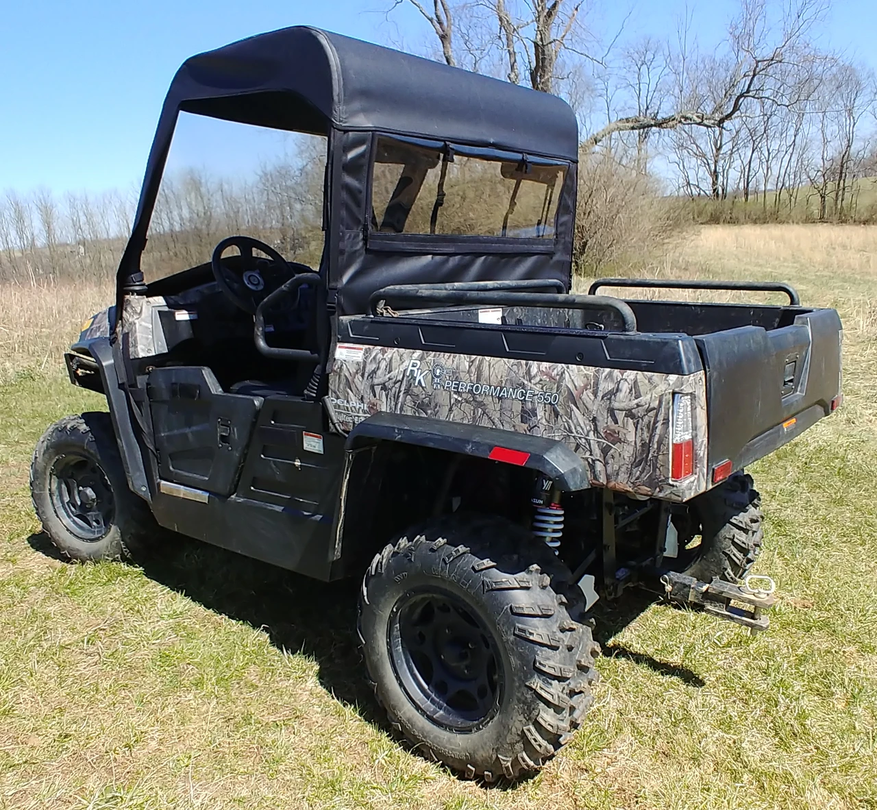 Rear three-quarter view of the 3 Star vinyl top and rear window on the camo Hisun Sector, passenger side