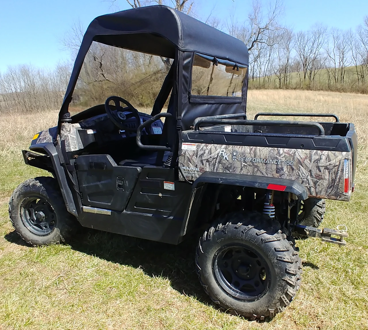 Driver side rear angle of the camo Hisun Sector 550/750 showing the 3 Star vinyl top and clear rear window