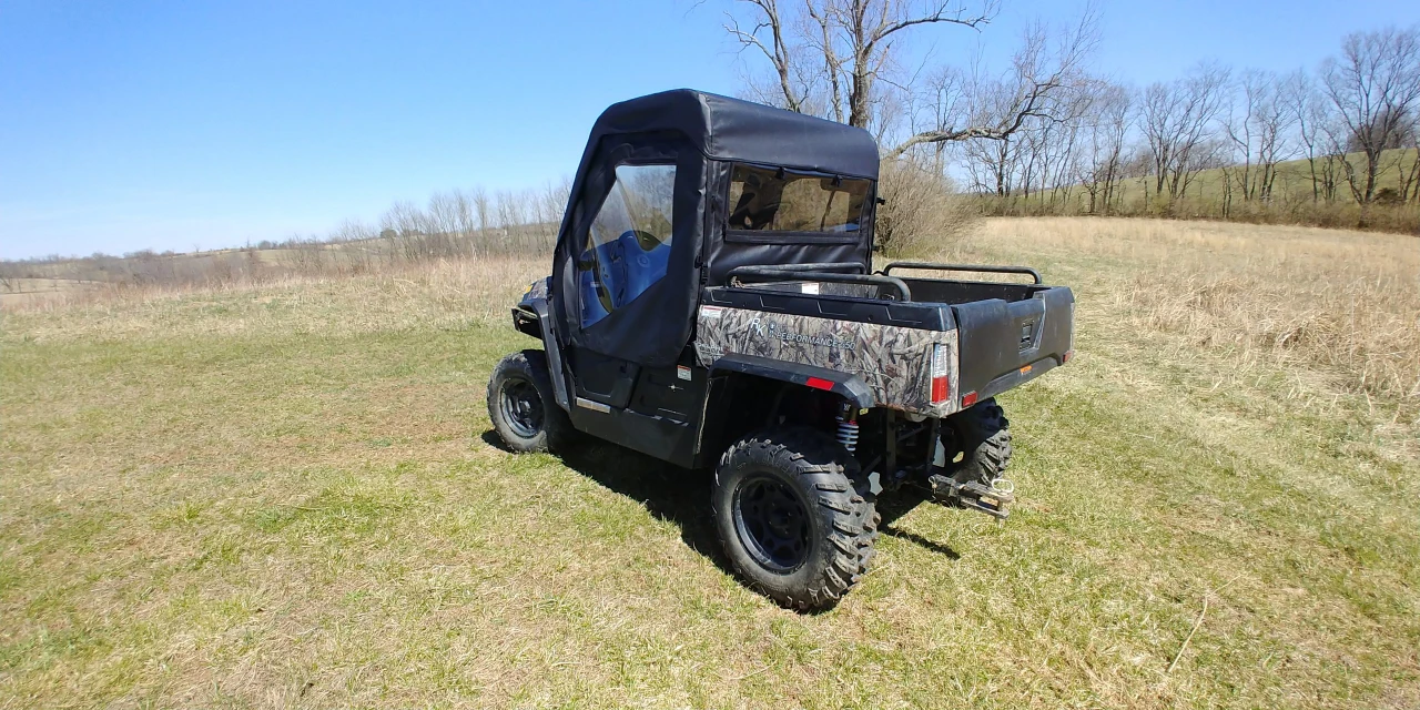Wide rear three-quarter view of a Hisun Sector with the 3 Star doors and rear window kit in an open field
