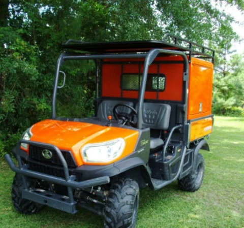 Front view of a Kubota RTV-X Series with the Wiedmann Bros utility bed box and window behind the cab