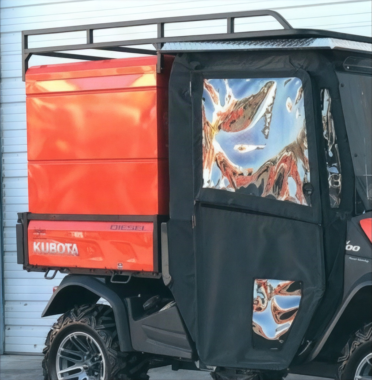 Wiedmann Bros orange steel utility bed cap with roof rack installed on an orange Kubota RTV-X with cab, side view