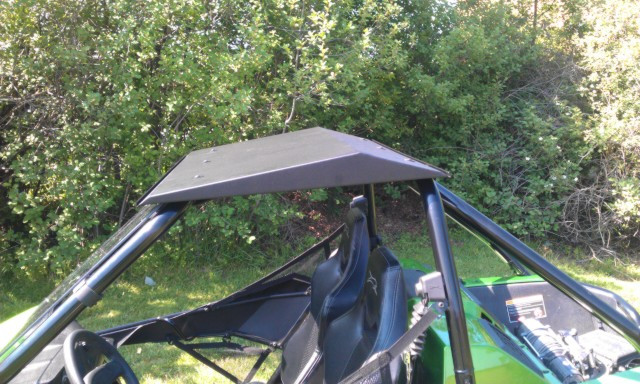 Rear three-quarter view of the black aluminum top over the cage and seats of the green Arctic Cat Wildcat 1000