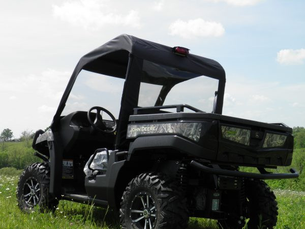 Rear three-quarter view of the 3 Star soft top and clear rear window on a camo John Deere Gator in a field