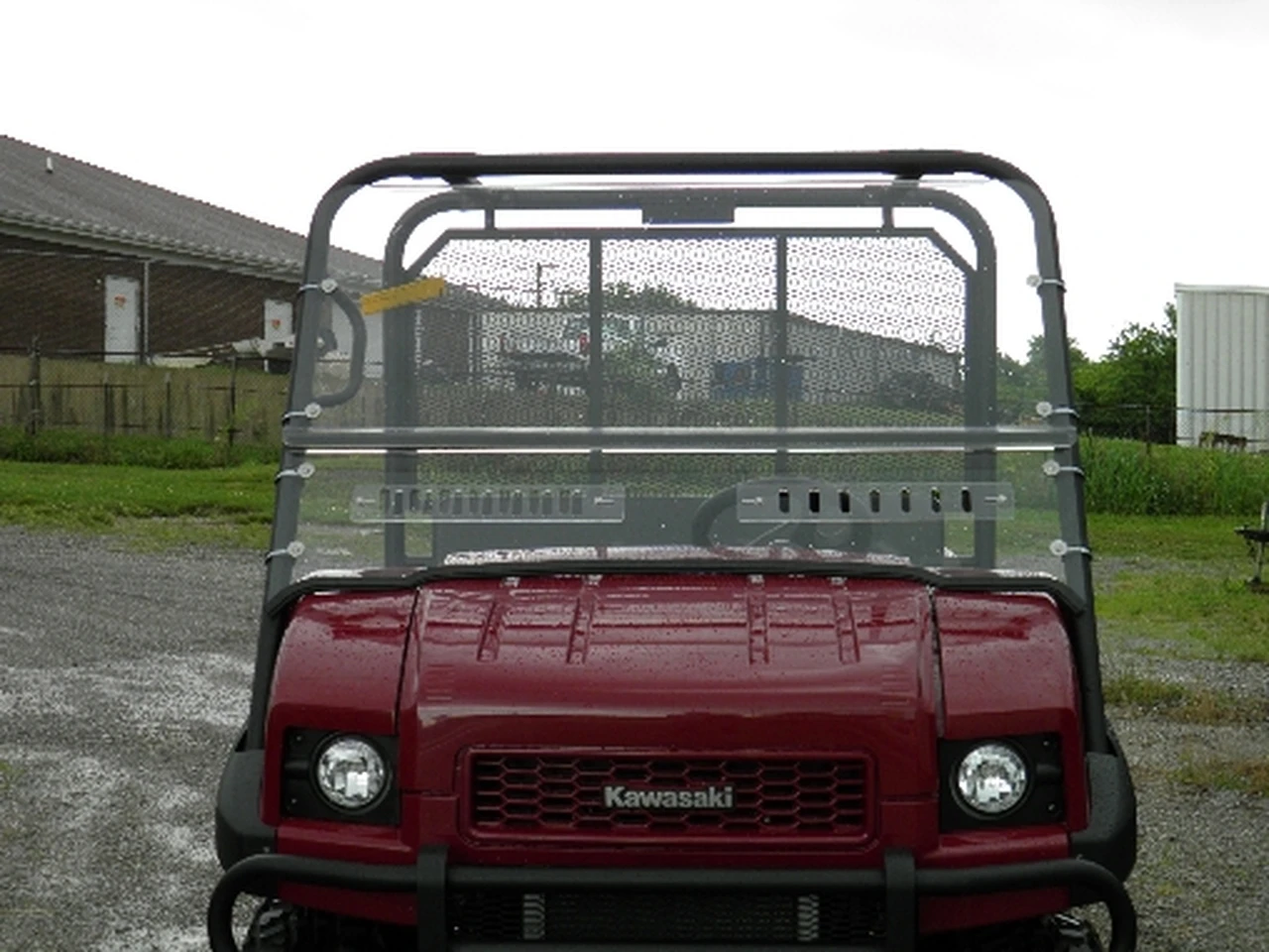 Front view of a red Kawasaki Mule 4010 with the 3 Star two-piece windshield installed