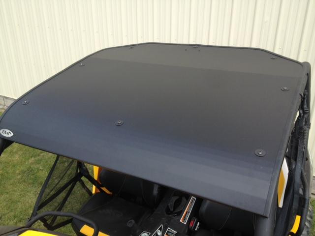 EMP aluminum top installed on a yellow Can-Am Maverick, black roof panel seen from above with front edge bolts