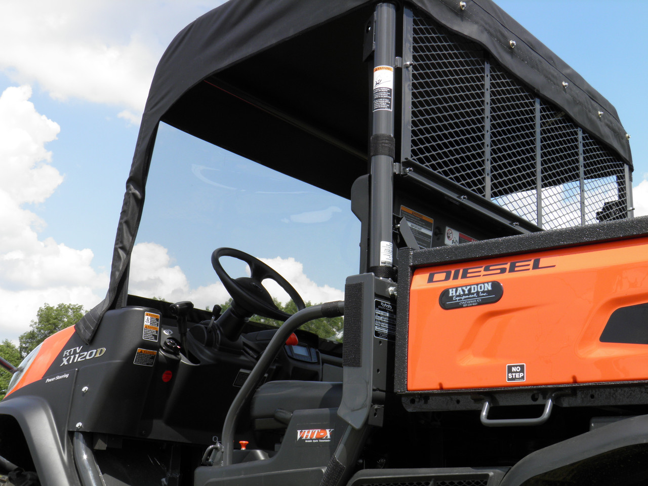 Close-up of the 3 Star soft top and vinyl windshield frame on the orange Kubota RTV X1120 cab