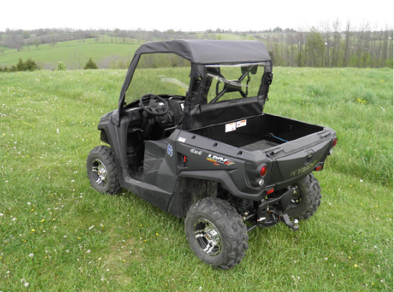 Rear three-quarter view of a Kymco 450 in a field with the 3 Star soft top and rear window installed