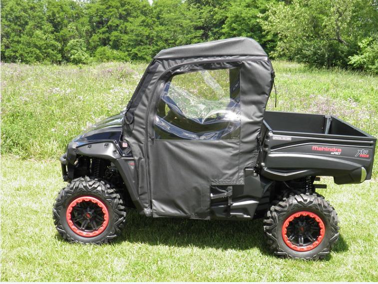 Side view of the black side-by-side with the 3 Star full cab enclosure doors zipped closed on grass