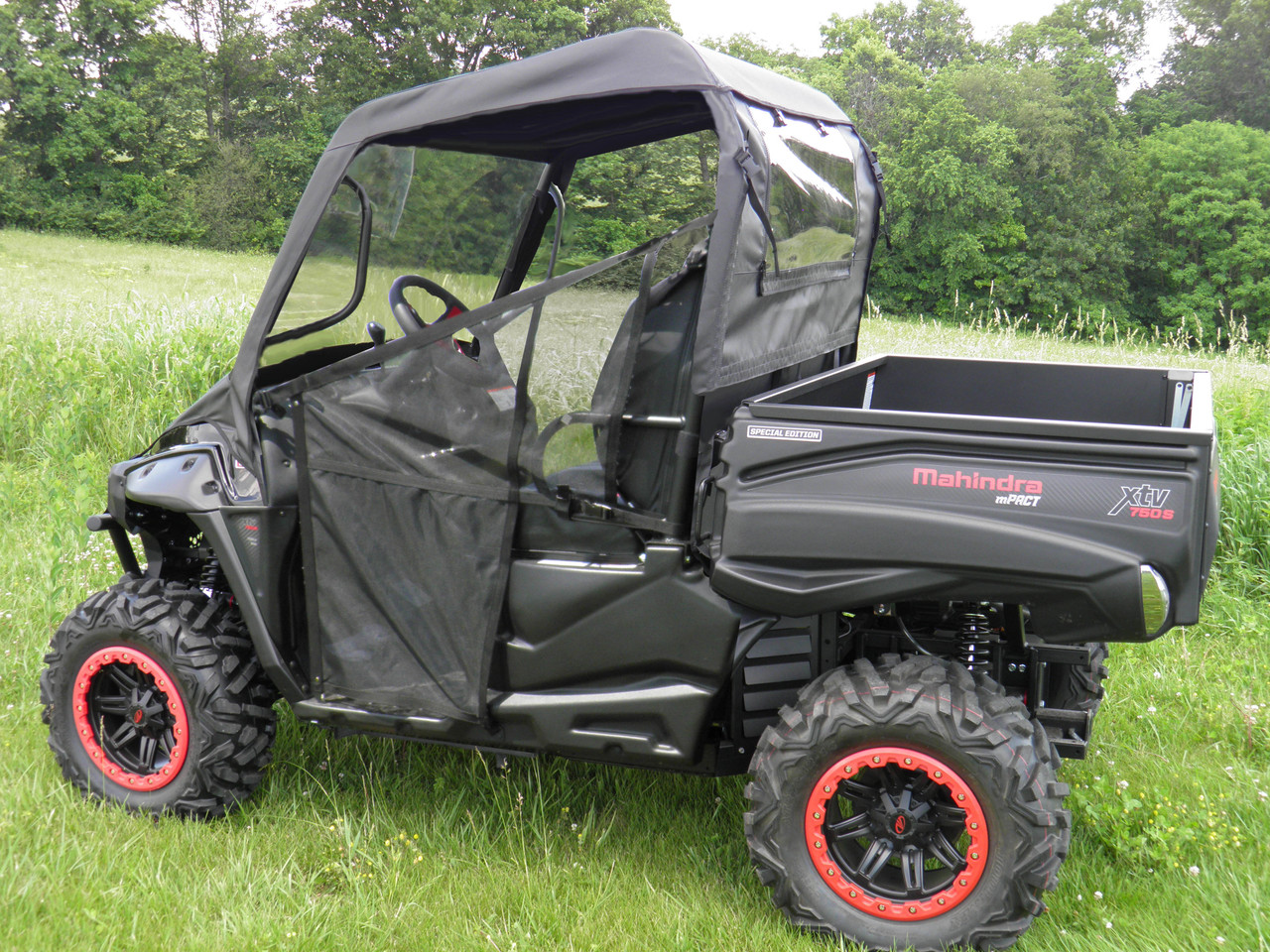 3 Star vinyl windshield, top and rear window installed on a black side-by-side with red-trim wheels, driver side view