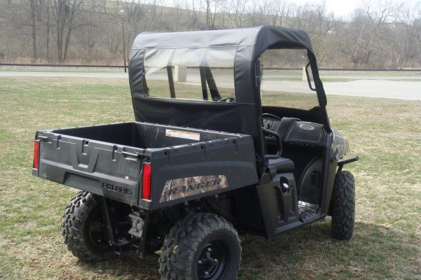 Rear three-quarter view of the 3 Star clear vinyl rear window and black top on a camo Polaris Ranger