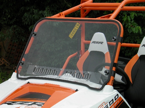 Angled view of the 3 Star one-piece windshield clamped to the orange cage of a Polaris RZR 800, vent slots visible