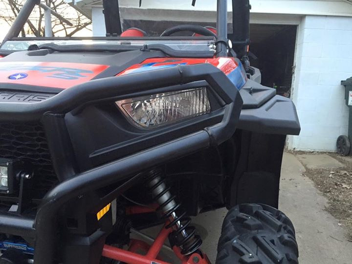 Front close-up of the Extreme Metal Products flare next to the headlight of a red and white Polaris RZR in a driveway